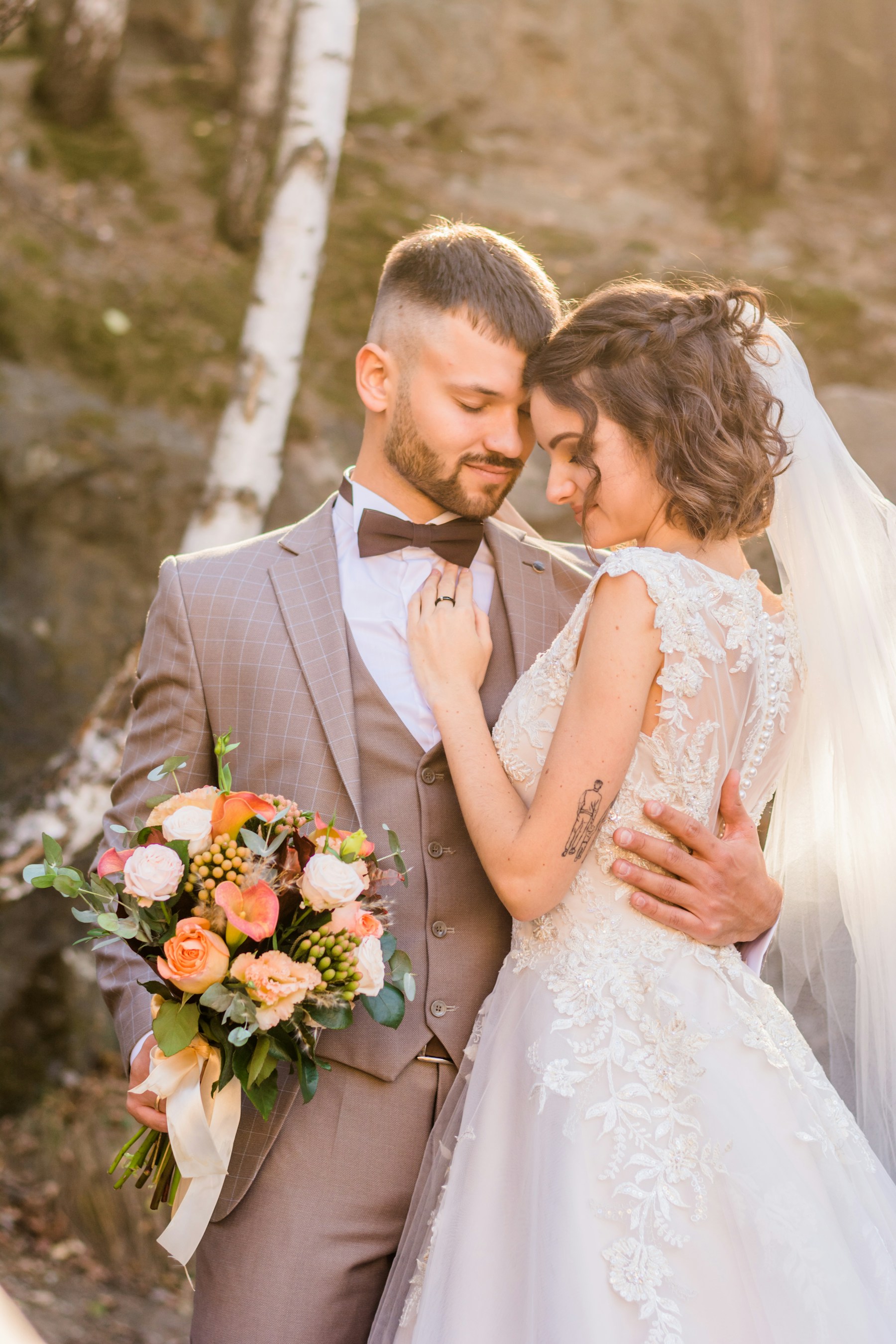 A bride and groom sharing a quiet embrace outdoors